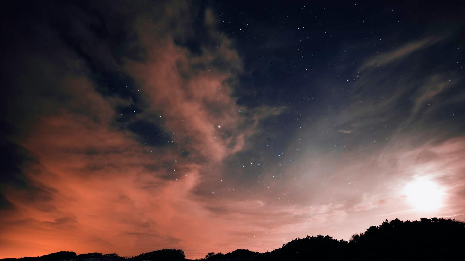A dark night sky with deep clouds catching the last of the light